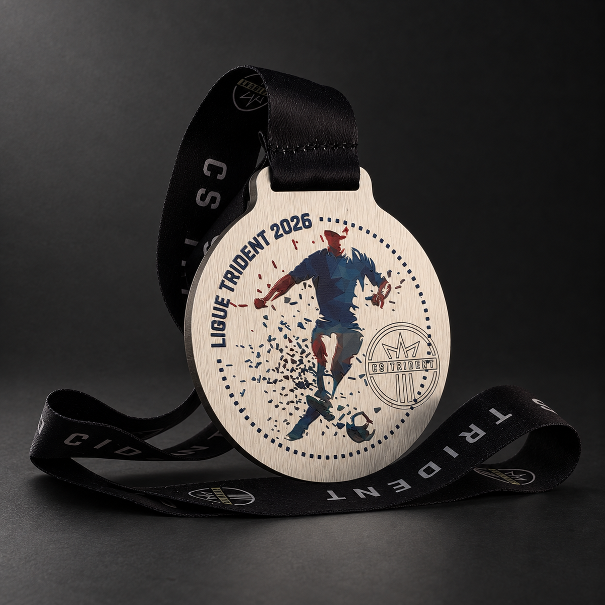 Médaille Ligue Trident 2026 en ACM ¼ po avec illustration de soccer et ruban personnalisé, sur fond graphite.