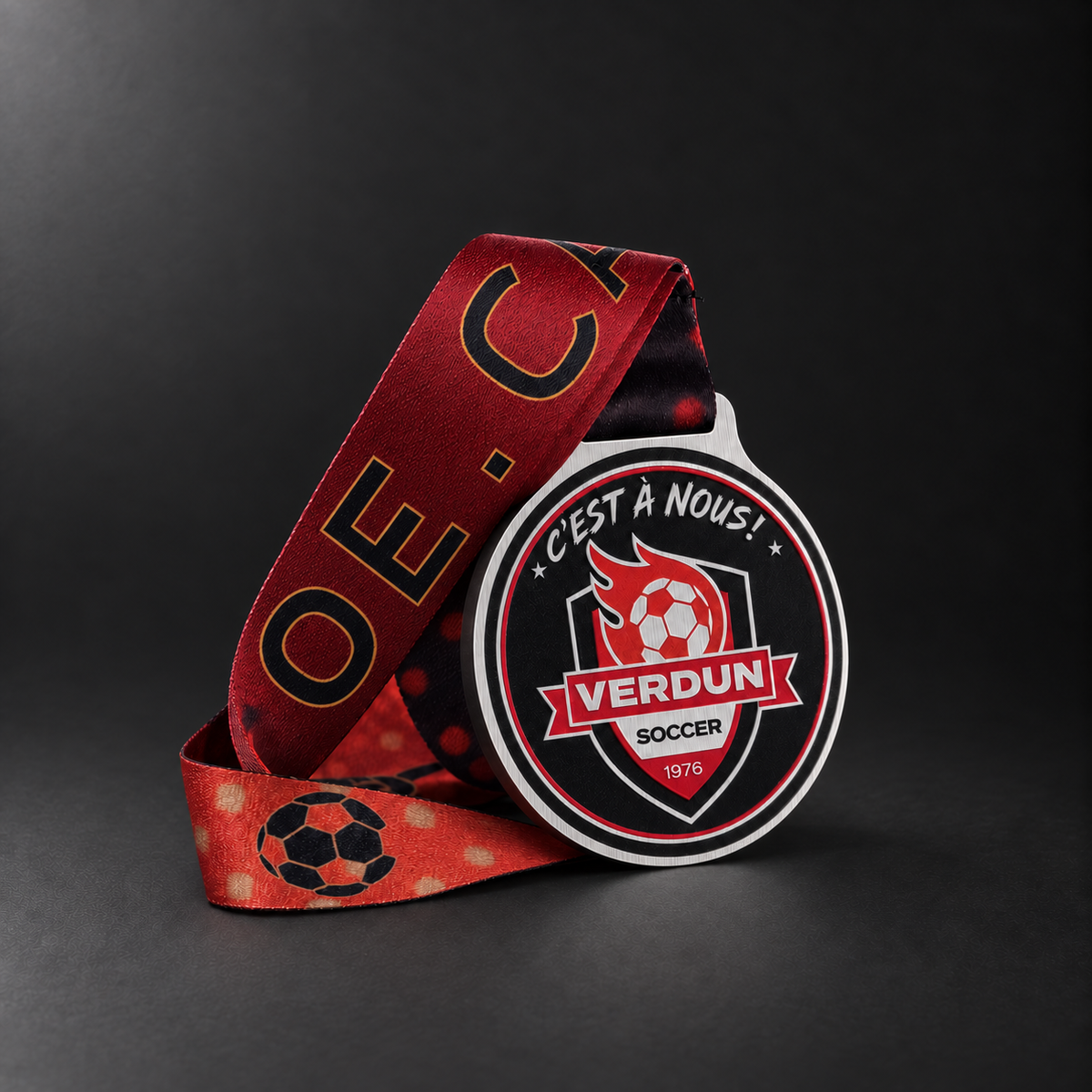 Médaille Verdun Soccer en ACM ¼ po avec ruban personnalisé rouge et noir, sur fond graphite.